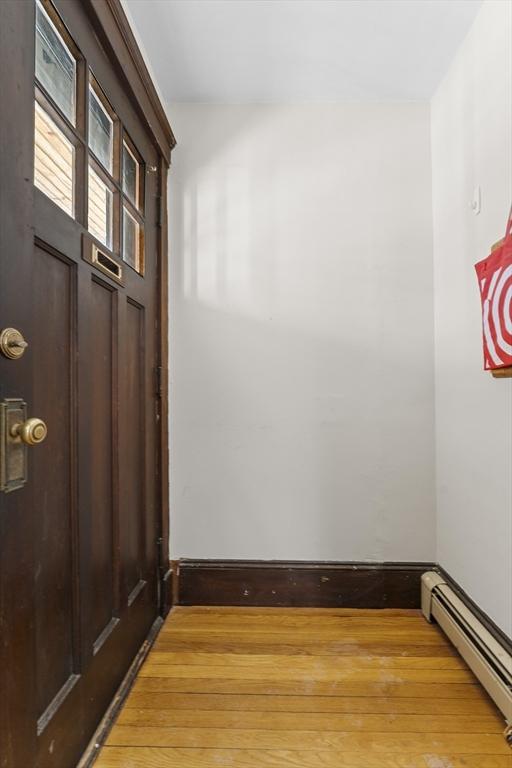 interior space with a baseboard heating unit and hardwood / wood-style floors