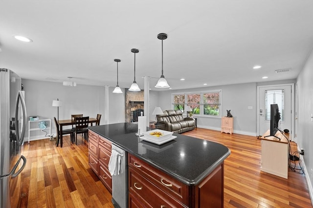 6 Birch Ln, Shrewsbury, MA 01545 - kitchen with freestanding refrigerator, dark countertops, wood finished floors, a stone fireplace, and open floor plan
