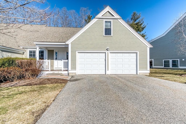 view of front of home with a porch, roof with shingles, driveway, and a garage