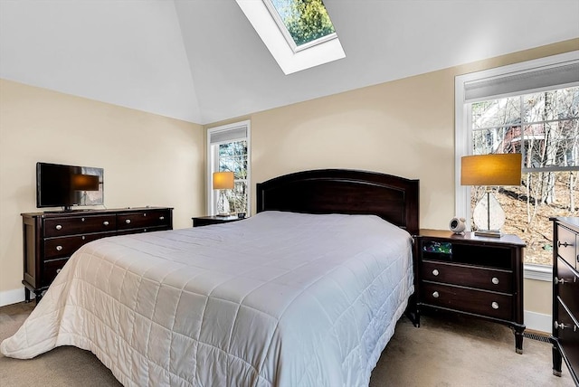 bedroom with lofted ceiling with skylight, carpet flooring, and baseboards