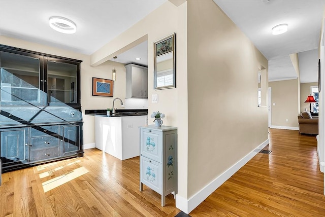 hall with baseboards and light wood finished floors