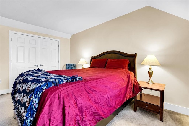 bedroom featuring carpet, a closet, vaulted ceiling, and baseboards