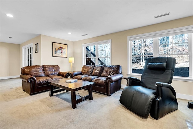 living room featuring light colored carpet, visible vents, and baseboards