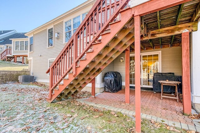 view of patio / terrace featuring stairs, cooling unit, and a grill