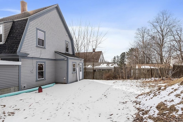 view of snow covered back of property