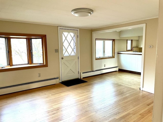 foyer with light wood-type flooring, a baseboard heating unit, and ornamental molding