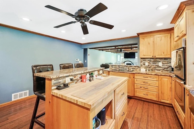 252 Howe St, East Brookfield, MA 01515 - kitchen with wooden counters, light brown cabinetry, a kitchen bar, wood finished floors, and recessed lighting