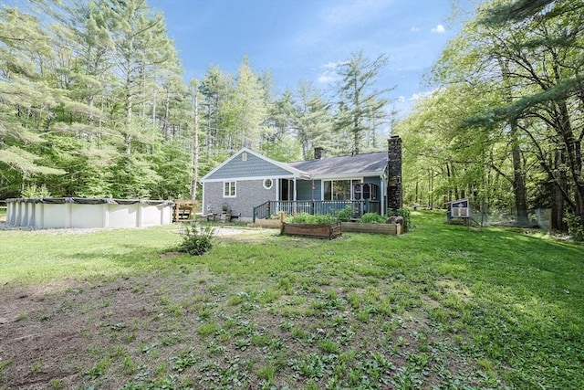 252 Howe St, East Brookfield, MA 01515 - rear view of property with a chimney, a covered pool, and a lawn