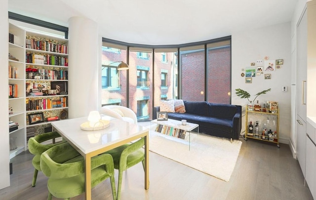 sitting room featuring a wall of windows and wood finished floors