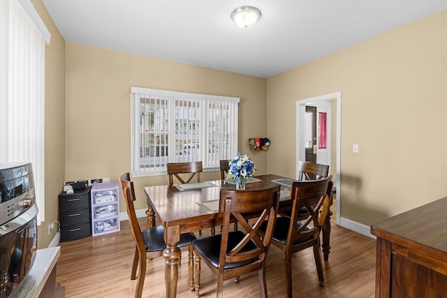 dining area featuring light wood-style floors and baseboards