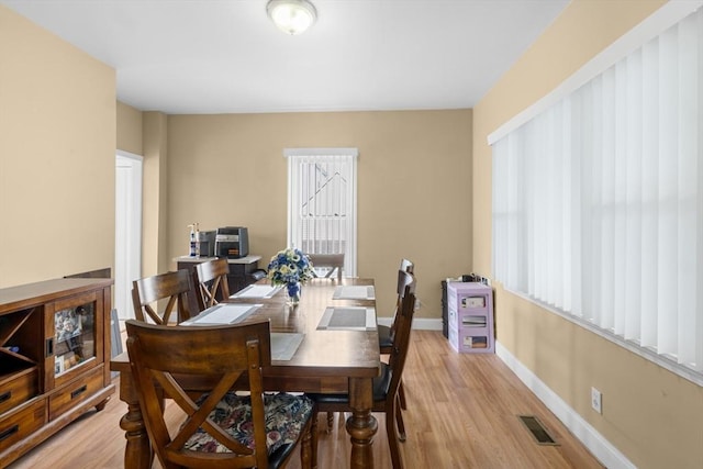 dining area featuring light wood finished floors, plenty of natural light, and baseboards