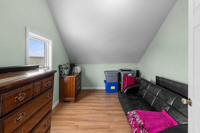 bonus room featuring lofted ceiling, light wood-style floors, and baseboards