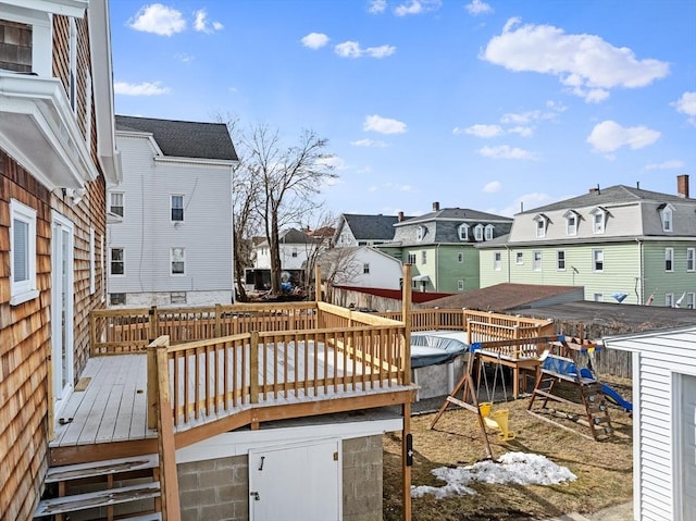 wooden terrace with a residential view and a playground