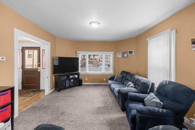 carpeted living room featuring baseboards