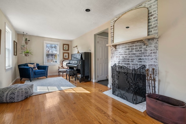 living room featuring light wood-type flooring and a fireplace