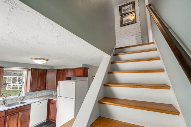 staircase with sink, a textured ceiling, and hardwood / wood-style flooring