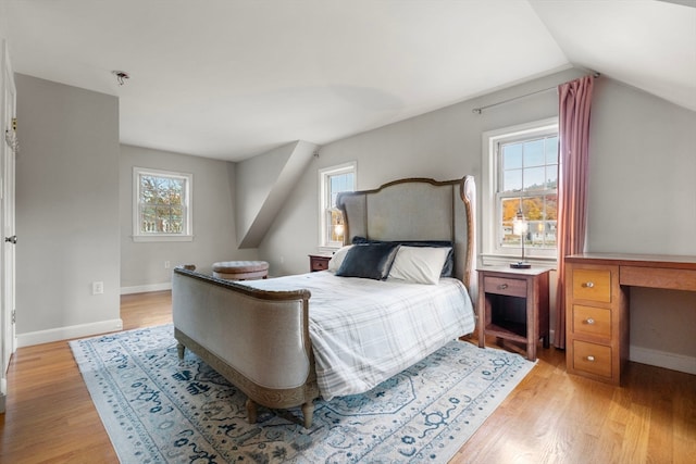 bedroom featuring light wood-type flooring and vaulted ceiling