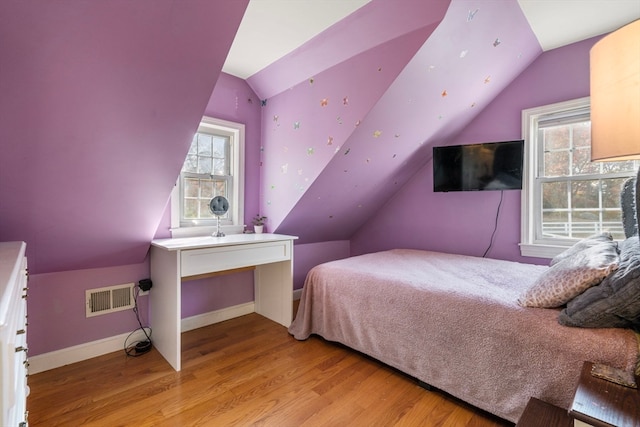 bedroom with light hardwood / wood-style floors and vaulted ceiling