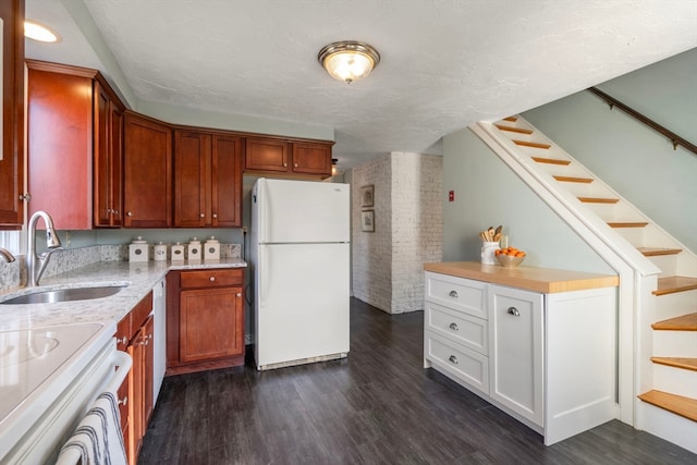 kitchen featuring dark hardwood / wood-style flooring, a textured ceiling, sink, and white appliances