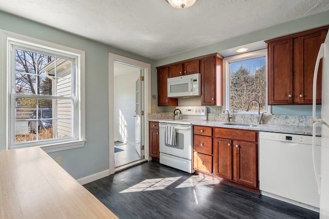 kitchen with sink, dark wood-type flooring, a textured ceiling, and white appliances