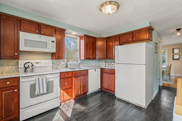 kitchen featuring white appliances, a textured ceiling, dark hardwood / wood-style flooring, and sink