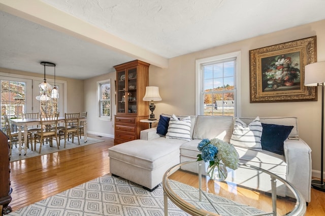 living room featuring beam ceiling and light hardwood / wood-style flooring