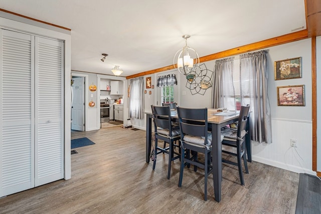 dining space featuring wood-type flooring and a chandelier