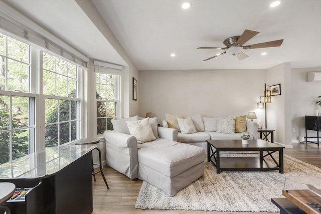 living room featuring recessed lighting, wood finished floors, ceiling fan, a wall mounted AC, and baseboards