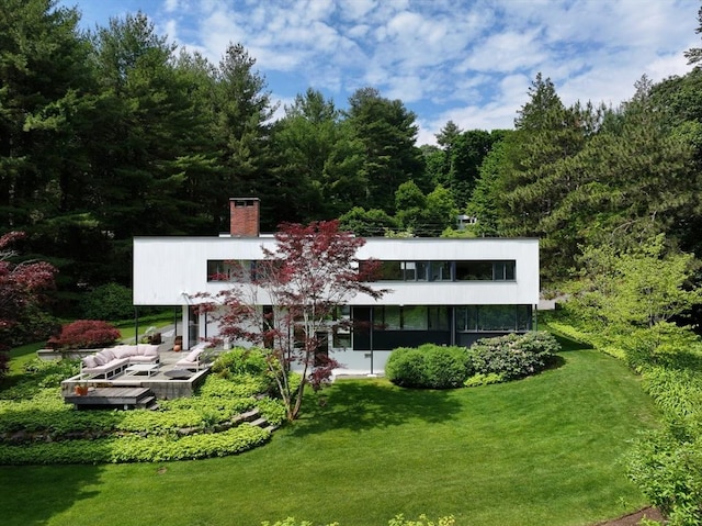 back of property with a lawn and a chimney