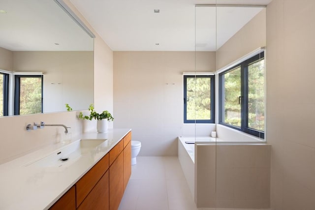 full bath with tile patterned floors, plenty of natural light, toilet, and vanity