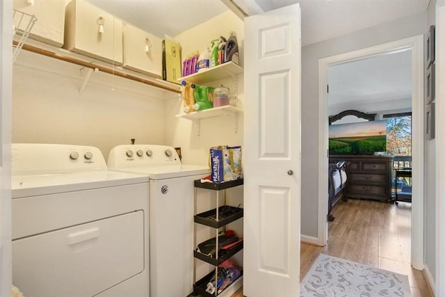 washroom with washer and dryer and light hardwood / wood-style floors