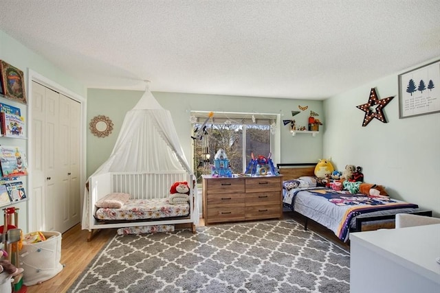 bedroom with dark hardwood / wood-style flooring, a closet, and a textured ceiling