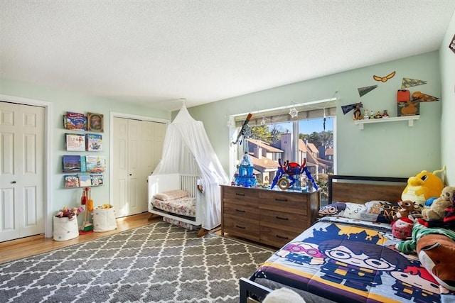 bedroom with dark hardwood / wood-style flooring and a textured ceiling