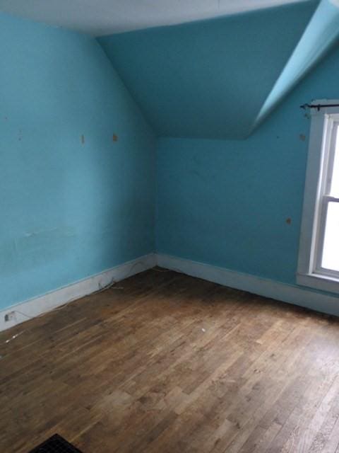 bonus room featuring vaulted ceiling and hardwood / wood-style flooring