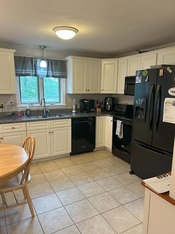 11 Solitaire Dr, Haverhill, MA 01830 - kitchen with black appliances, light tile patterned floors, white cabinets, and dark stone counters