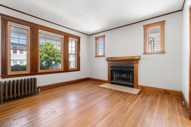 25-27 Morrow Rd, Boston, MA 02135 - unfurnished living room with radiator heating unit, ornamental molding, hardwood / wood-style flooring, and a fireplace