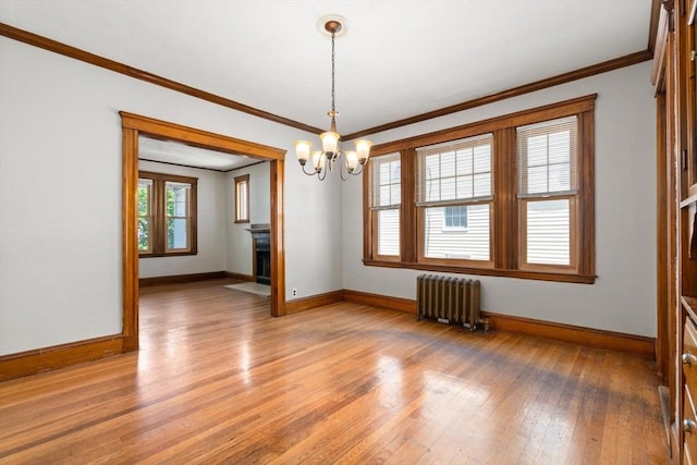 25-27 Morrow Rd, Boston, MA 02135 - empty room with radiator heating unit, light wood finished floors, a chandelier, crown molding, and a fireplace with flush hearth