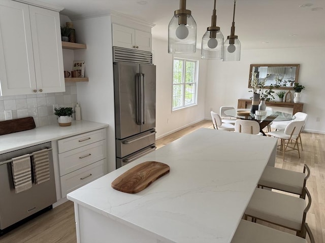 54 Vose St, Framingham, MA 01702 - kitchen featuring appliances with stainless steel finishes, open shelves, light wood finished floors, white cabinets, and decorative backsplash