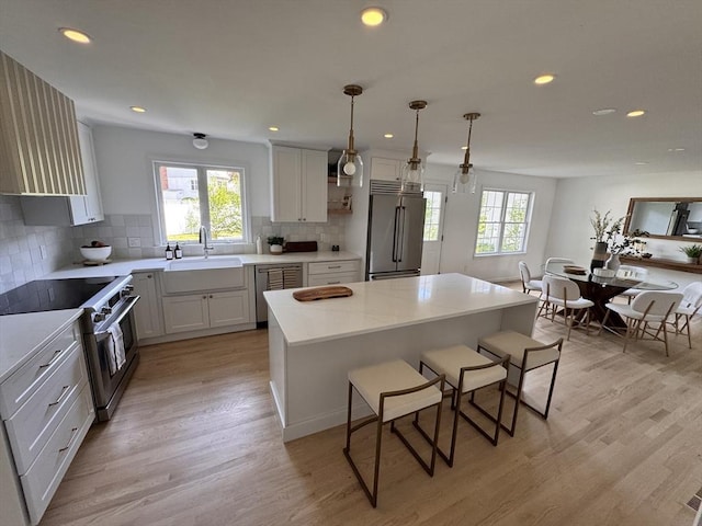 54 Vose St, Framingham, MA 01702 - kitchen with high end appliances, a breakfast bar, healthy amount of natural light, light wood finished floors, and recessed lighting