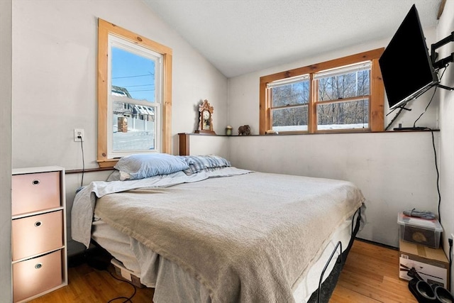 bedroom with light hardwood / wood-style floors and lofted ceiling