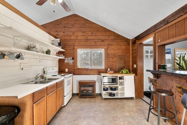 kitchen with electric range, wood walls, and vaulted ceiling