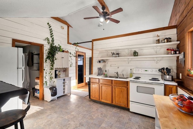 kitchen featuring ceiling fan, sink, white appliances, wooden walls, and lofted ceiling