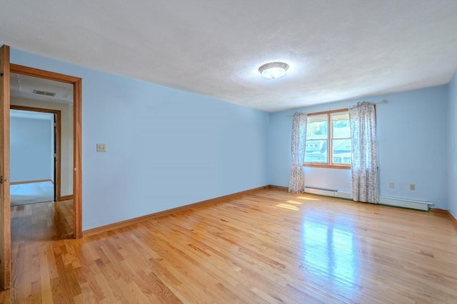 12 Jensen Ave, Chelmsford, MA 01824 - empty room with light wood-style floors, a baseboard radiator, and baseboards