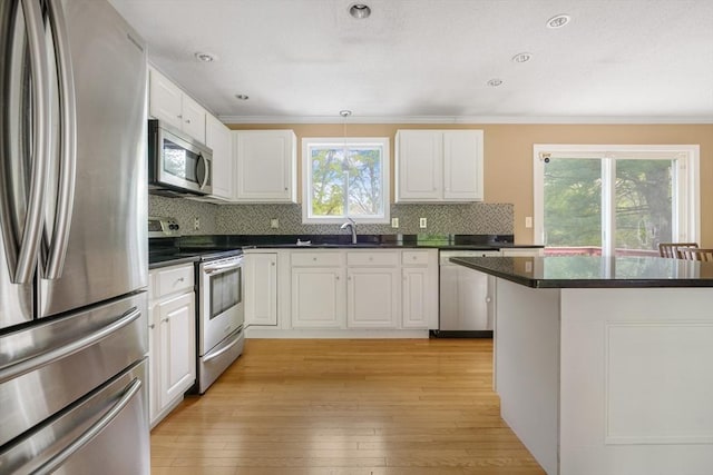 998 Wood, Swansea, MA 02777 - kitchen featuring appliances with stainless steel finishes, a sink, dark countertops, white cabinets, and tasteful backsplash