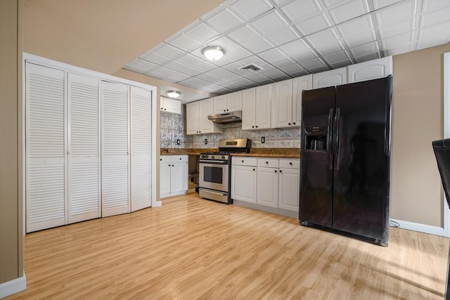 998 Wood, Swansea, MA 02777 - kitchen with black refrigerator with ice dispenser, stainless steel range with gas stovetop, light wood finished floors, dark countertops, and white cabinets
