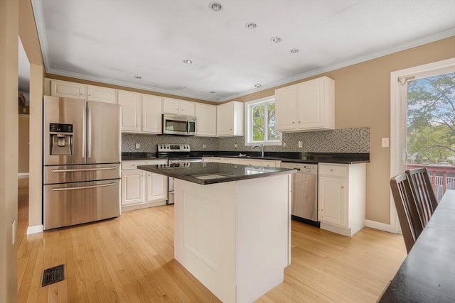 998 Wood, Swansea, MA 02777 - kitchen with appliances with stainless steel finishes, light wood-type flooring, backsplash, white cabinetry, and ornamental molding