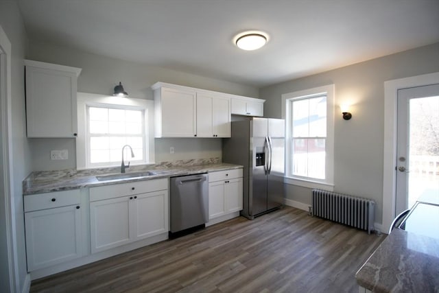 kitchen featuring dark wood finished floors, radiator heating unit, white cabinets, stainless steel appliances, and a sink