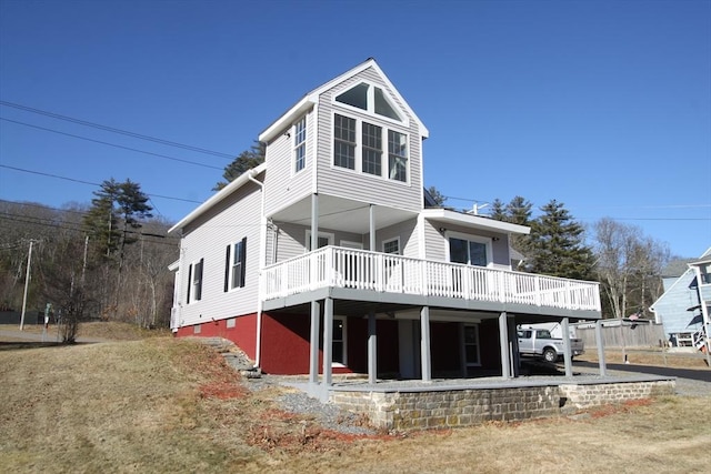 back of house with a carport and a deck