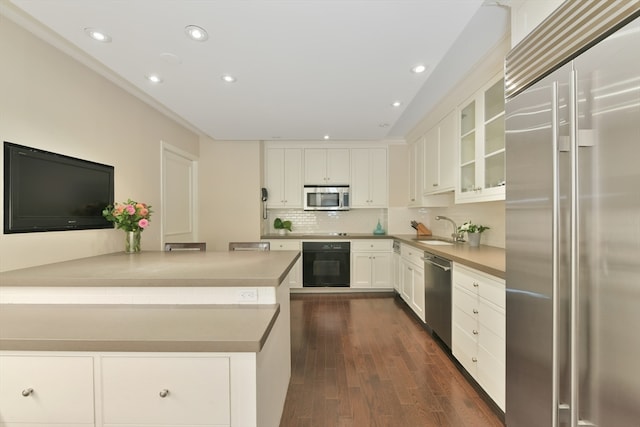 kitchen featuring tasteful backsplash, white cabinets, stainless steel appliances, dark hardwood / wood-style floors, and sink