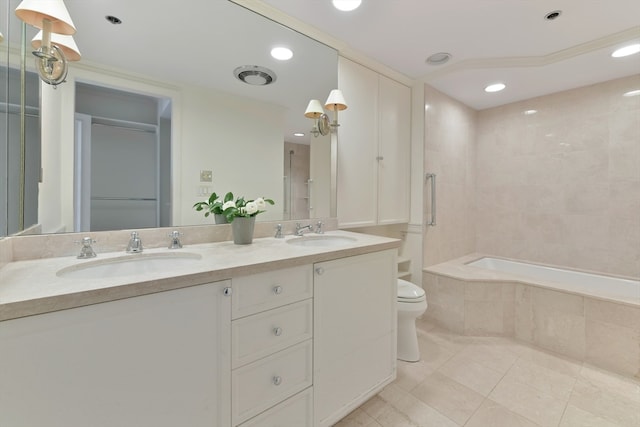 bathroom with vanity, tiled bath, toilet, and tile patterned floors